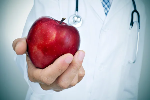 Arzt mit einem Apfel, der die Idee der gesunden Ernährung darstellt — Stockfoto