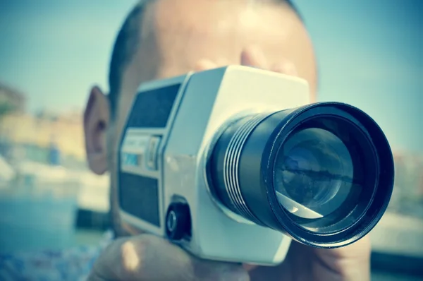 Ung man filma med en retro filmkamera — Stockfoto