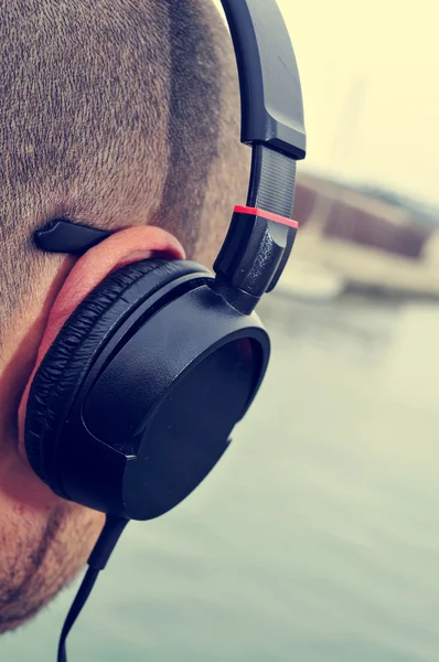 Young man listening to music in front of the sea — Stock Photo, Image