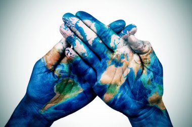 man hands patterned with a world map (furnished by NASA) clipart
