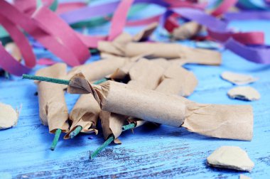 streamers, confetti and firecrackers on a rustic blue wooden sur clipart