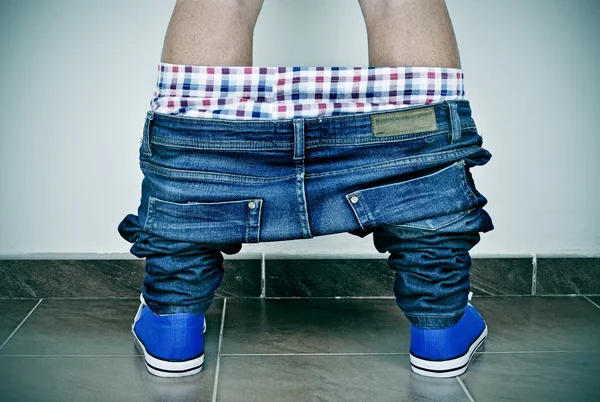 Jonge man met zijn broek omlaag gezien van achteren — Stockfoto