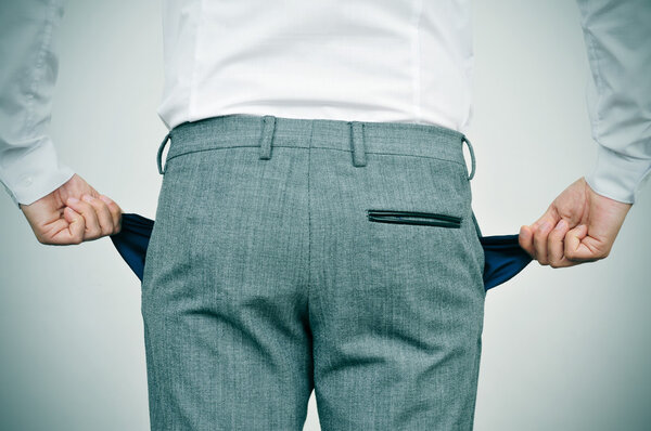 Разрушенный бизнесмен показывает свои пустые карманы
