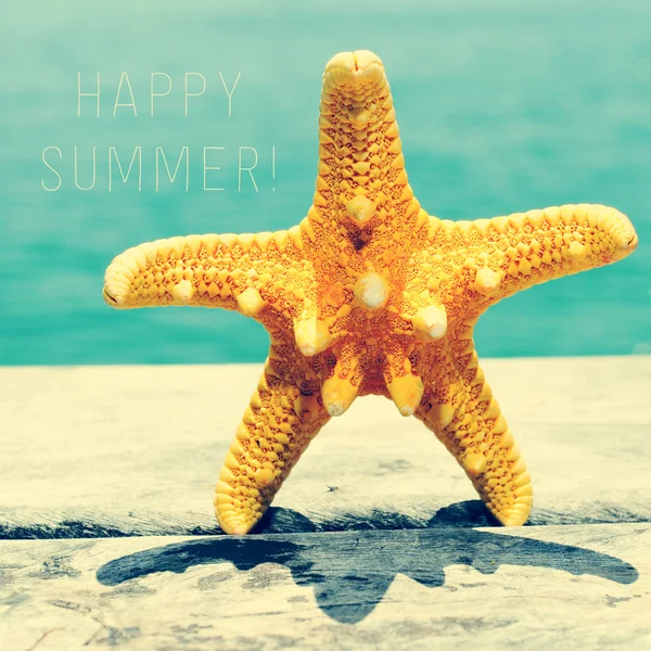 Starfish on wooden pier and text happy summer — Zdjęcie stockowe