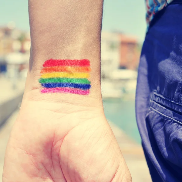 Homem com uma bandeira do arco-íris pintado em seu pulso — Fotografia de Stock