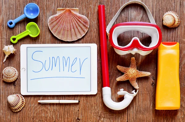 Word summer written in a tablet and summer stuff — Stockfoto