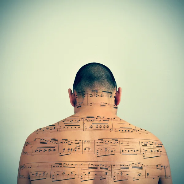 Man with a musical score patterned in his back — Stock fotografie