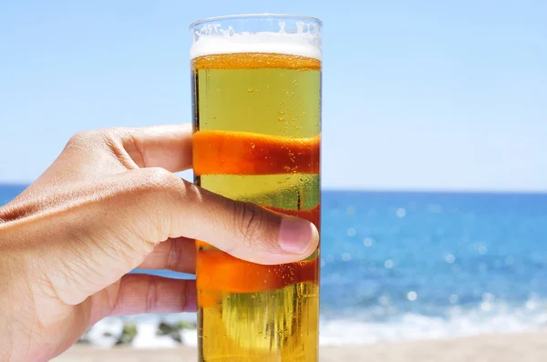 Молодий чоловік має пиво на пляжі — стокове фото