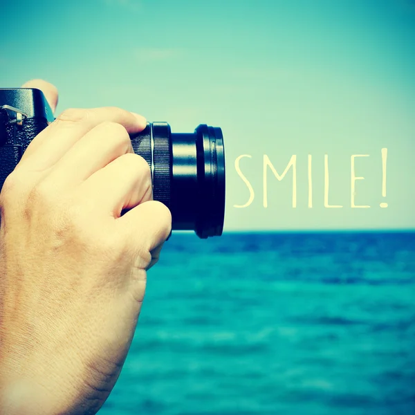 Man taking a picture and the text smile!, with a retro effect — Stock Photo, Image