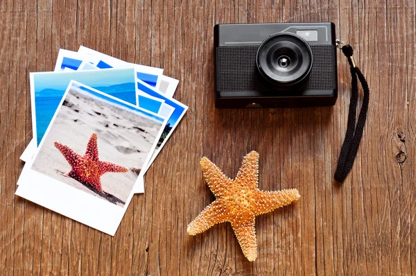 Fotocamera retrò, stelle marine e alcune foto su una superficie di legno — Foto Stock
