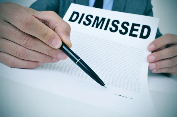 Businessman shows a document with the text dismissed — Stock Photo, Image