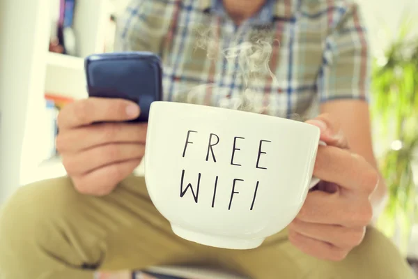 Young man with a smartphone and a cup of coffee with the text fr — Stock Fotó