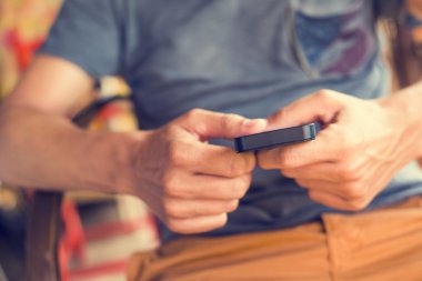 rustik bir yerde bir akıllı telefon ile genç adam