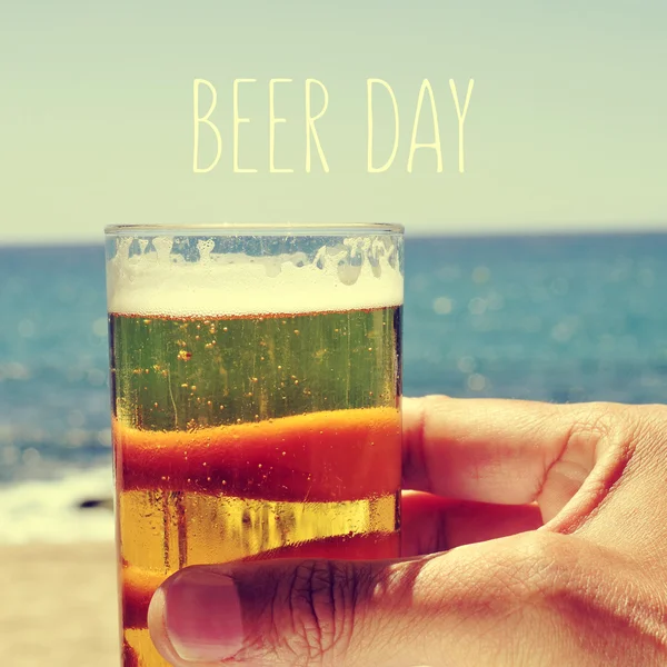 Hombre con una cerveza y el día de la cerveza de texto — Foto de Stock