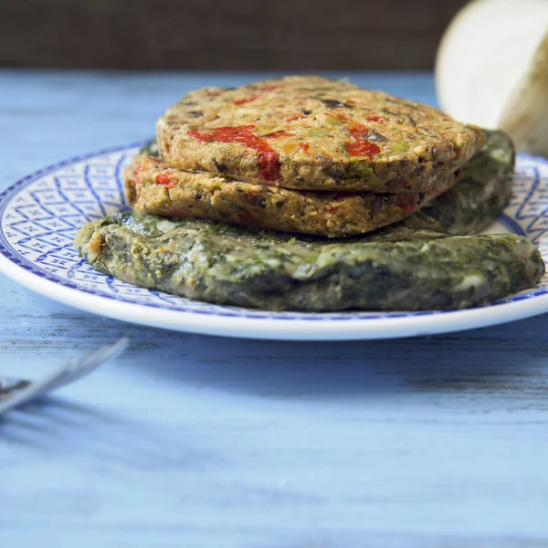 Raw veggie burgers on a rustic blue table — Stock Photo, Image