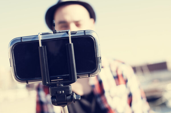 young man taking a selfie with a monopod