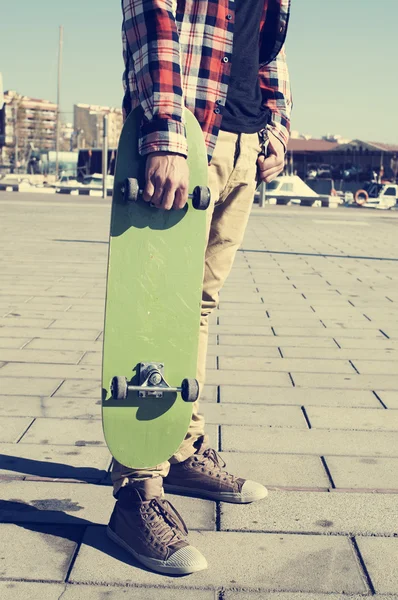 Joven con un monopatín — Foto de Stock