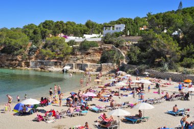 sunbathers at Cala Gracio beach in San Antonio, Ibiza Island, Sp