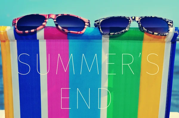 Sunglasses on colorful deck chair and text summers end — Stock Photo, Image