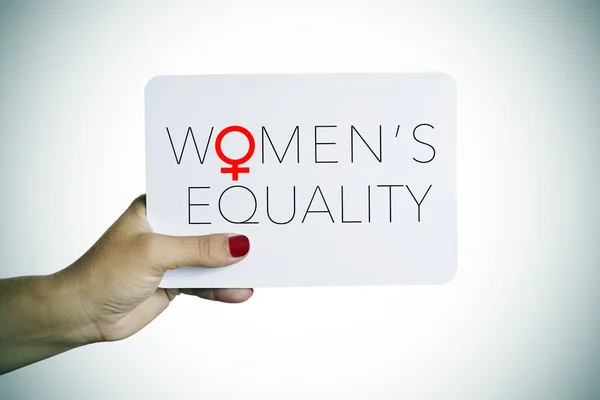 Nő tart egy jelzőtábla a szöveg női egyenlőség — Stock Fotó