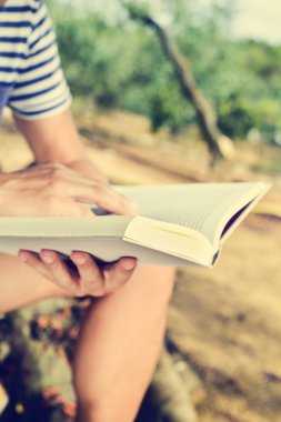 genç adam açık havada bir kitap okuma