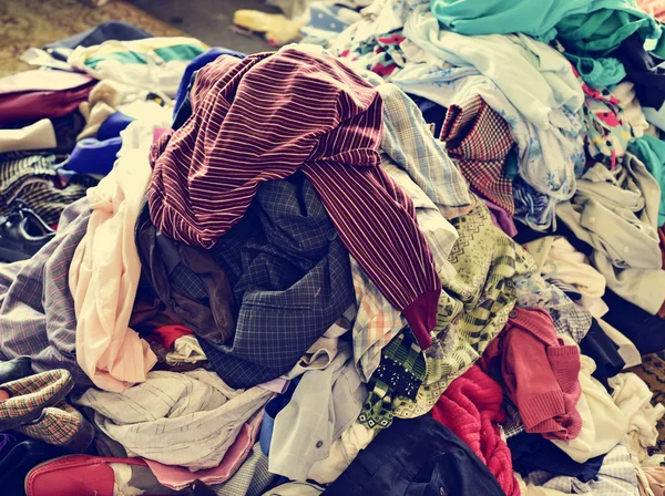 Pile of used clothes on sale in a flea market — Stock Photo, Image
