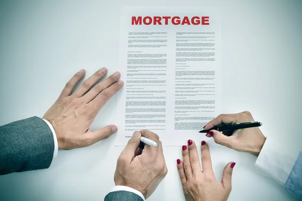 Homem e mulher assinando um contrato de empréstimo hipotecário — Fotografia de Stock