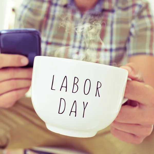 Ung man med en mugg med texten labor day — Stockfoto