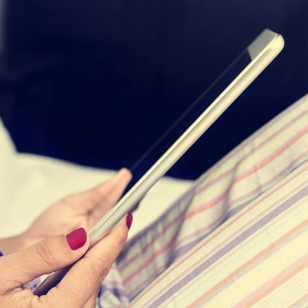 Junge Frau mit Tablette im Bett, gefiltert — Stockfoto