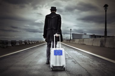 young man with a rolling suitcase with an European flag clipart