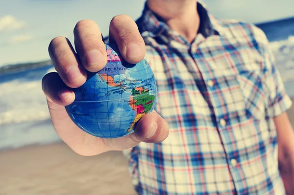 Young man with a world globe in his hand — Stock Photo, Image