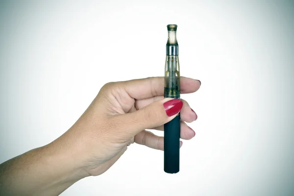 Jeune femme montrant une cigarette électronique, vignetté — Photo