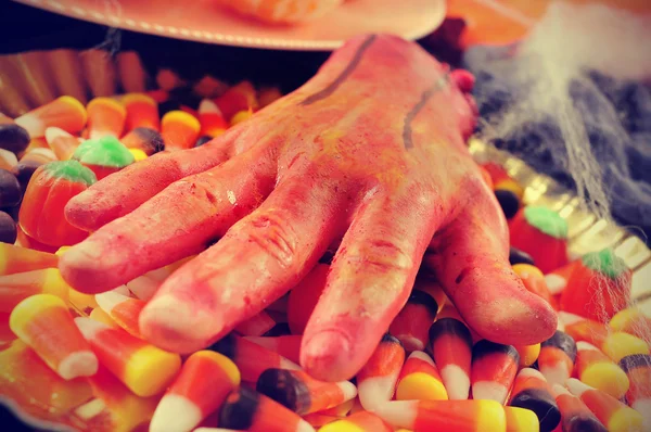 Amputated hand and Halloween candies, filtered — Stock Photo, Image