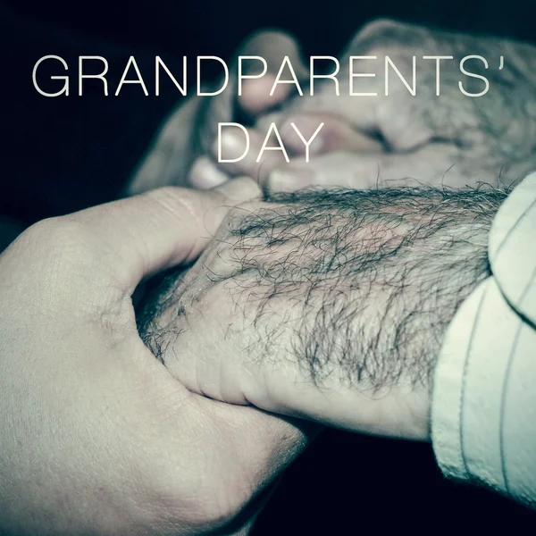 Jovem segurando as mãos de um homem velho e o texto grandpare — Fotografia de Stock