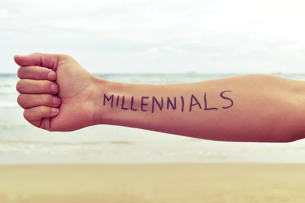 Молодой человек со словом millennials, написанным на его руке — стоковое фото