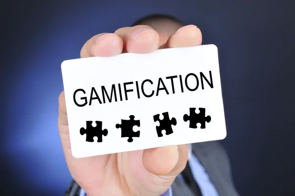 Młody człowiek w garniturze pokazuje szyld z gamification słowo — Zdjęcie stockowe