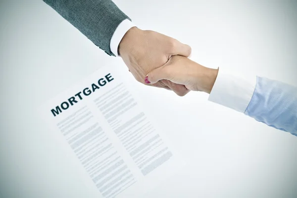 Mortgage loan and man and woman shaking hands — Stock Photo, Image