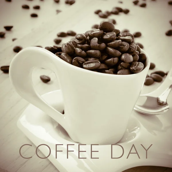 Testo giorno caffè e tazza piena di chicchi di caffè torrefatto — Foto Stock