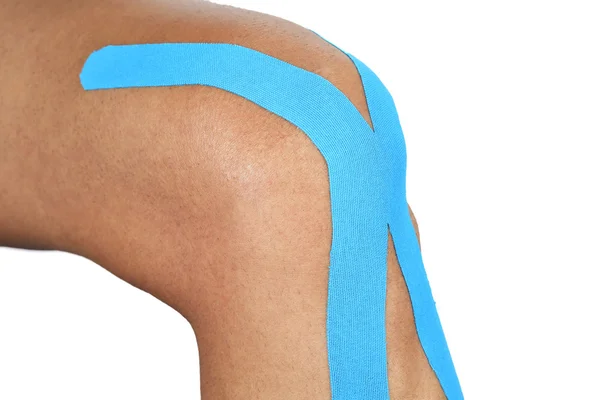 Junger Mann mit elastischem Therapieband im Knie — Stockfoto