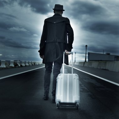 young man with a rolling suitcase, with a dramatic effect clipart