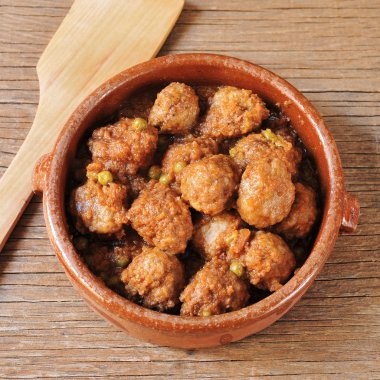 spanish meatballs stew on a wooden rustic table clipart