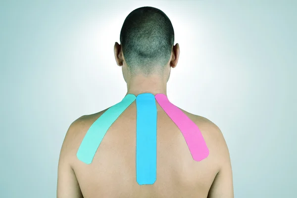 Uomo con alcune strisce di nastro elastico terapeutico — Foto Stock