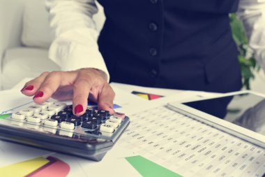 Onun ofisinde bir elektronik hesap makinesi kullanarak iş kadını