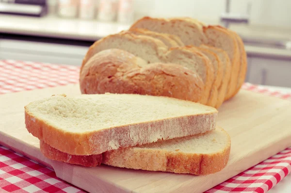 Plátky španělské bochník chleba na kuchyňském stole — Stock fotografie