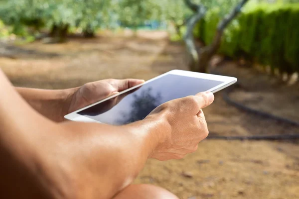 Genç adam açık havada bir tablet bilgisayar kullanarak — Stok fotoğraf