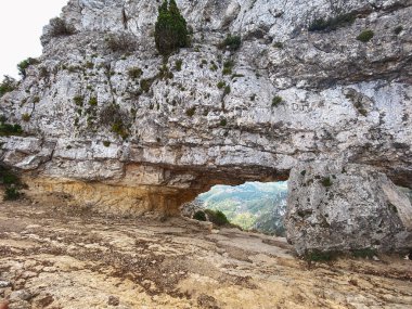 La Forada 'nın geniş bir görüntüsü, Serra del Montsia, İspanya' nın kuzey zirvesinde, derin vadilere ve katmanlı kireç taşı oluşumlarına bakan delinmiş kaya kemeri.