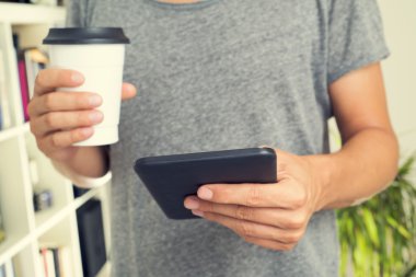 Genç adam tablet bilgisayar kullanıyor.