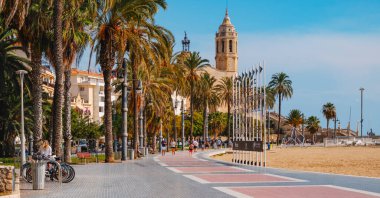 Sitges, İspanya - 17 Ekim 2025: İspanya 'nın Sitges kentindeki Passeig de la Ribera gezinti alanı, palmiye ağaçları, insanlar yürüyor ve 58. Sitges Uluslararası Fantastik Film Festivali tabelası