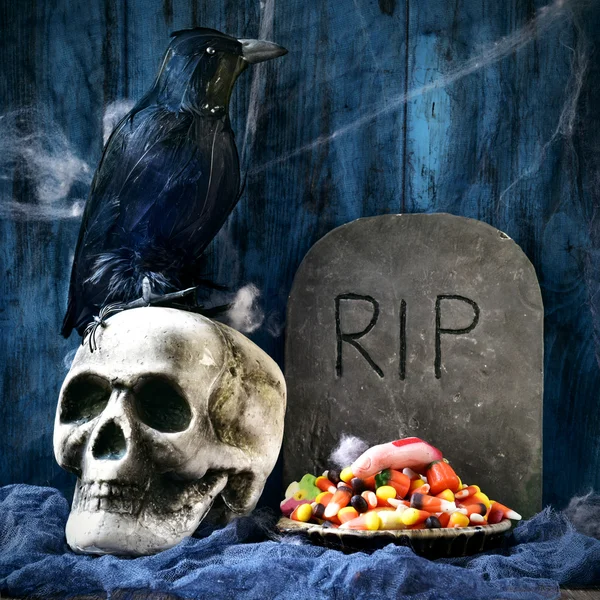 Cuervo, cráneo, lápida y dulces de Halloween —  Fotos de Stock