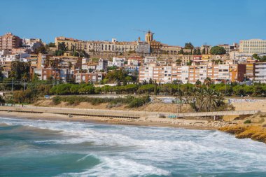 Tarragona, İspanya - 23 Ekim 2025: Tarragona 'da Playa del Miracle, yamaçta yükselen konut binaları ve arka planda Part Alta olarak bilinen şehrin eski çeyreği